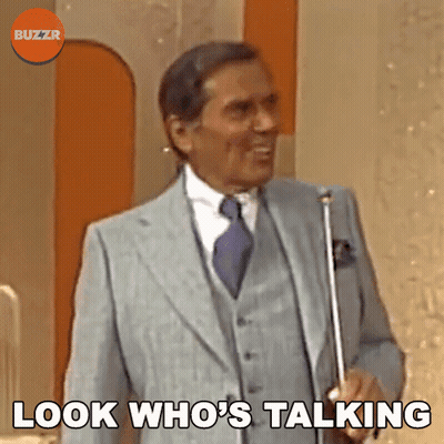 A Man In A Suit And Tie Is Holding An Umbrella And Says " Look Who 'S Talking " GIF