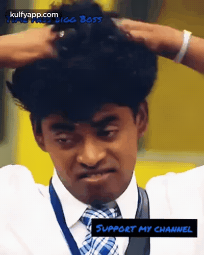 A Man In A Suit And Tie Is Holding His Hair In His Hands GIF