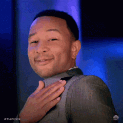 A Man In A Suit And Tie Is Holding His Hand To His Chest . GIF