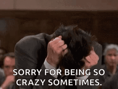 A Man In A Suit And Tie Is Holding His Head In His Hands And Says `` Sorry For Being So Crazy Sometimes . '' GIF