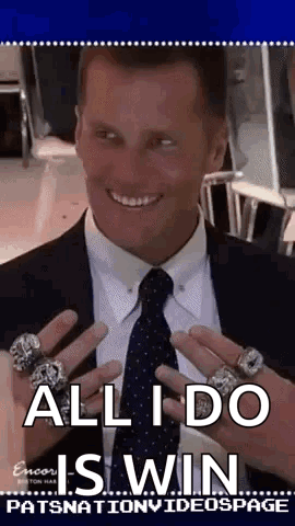 A Man In A Suit And Tie Is Holding Up His Rings . GIF