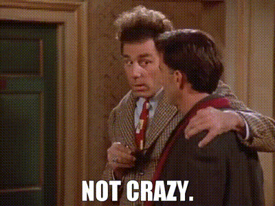 A Man In A Suit And Tie Is Hugging Another Man With The Words Not Crazy Written On The Screen . GIF