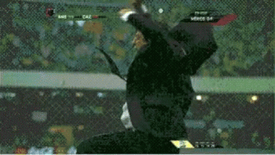A Man In A Suit And Tie Is Jumping In The Air During A Soccer Match GIF