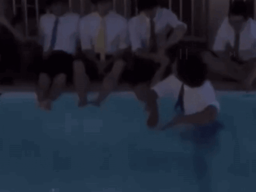 A Man In A Suit And Tie Is Jumping Into A Pool GIF