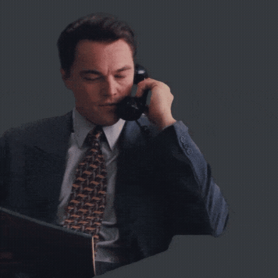 A Man In A Suit And Tie Is Laughing And Clapping His Hands GIF