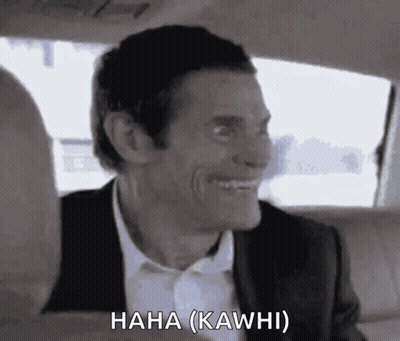 A Man In A Suit And Tie Is Laughing In A Car . GIF
