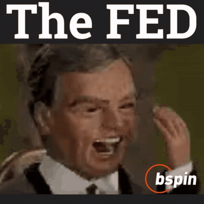 A Man In A Suit And Tie Is Laughing In Front Of The Fed Logo GIF