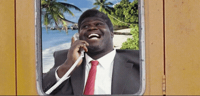 A Man In A Suit And Tie Is Laughing While Talking On The Phone GIF