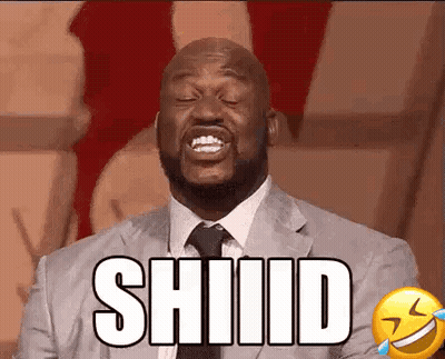 A Man In A Suit And Tie Is Laughing With His Eyes Closed And The Word Shiiid On His Face . GIF