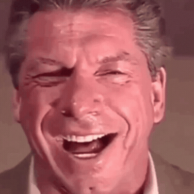 A Man In A Suit And Tie Is Laughing With His Eyes Closed . GIF