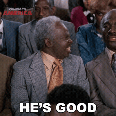 A Man In A Suit And Tie Is Laughing With The Words He 'S Good Below Him GIF