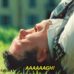 A Man In A Suit And Tie Is Laying In The Grass With The Words " Aaaaagh " Written Below Him GIF