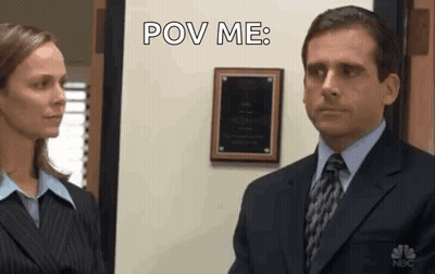 A Man In A Suit And Tie Is Looking At A Woman In A Suit And Tie . GIF