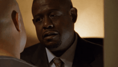 A Man In A Suit And Tie Is Looking At Another Man GIF