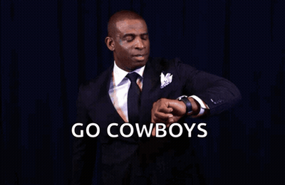 A Man In A Suit And Tie Is Looking At His Watch With The Words Go Cowboys You Know What Time It Is GIF