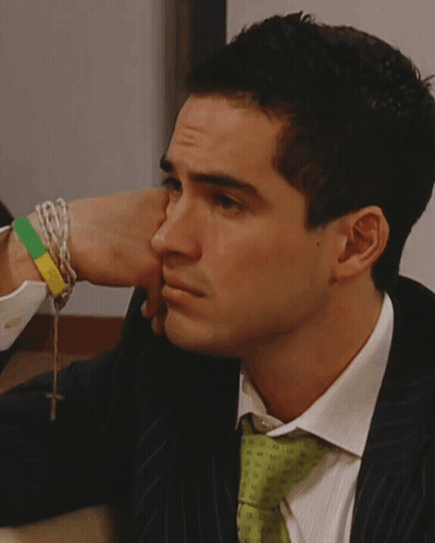 A Man In A Suit And Tie Is Looking At Something GIF