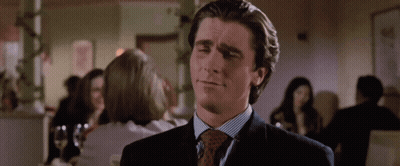 A Man In A Suit And Tie Is Looking At Something GIF