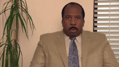 A Man In A Suit And Tie Is Looking At The Camera GIF
