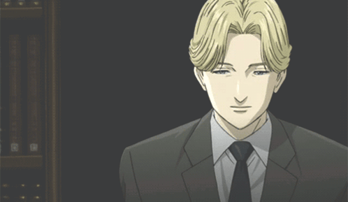 A Man In A Suit And Tie Is Looking At The Camera GIF