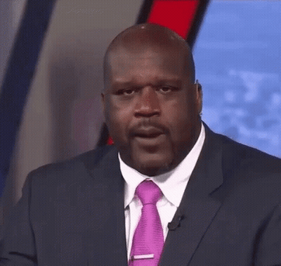 A Man In A Suit And Tie Is Looking At The Camera . GIF
