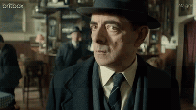 A Man In A Suit And Tie Is Looking At The Camera With A Britbox Logo In The Corner GIF