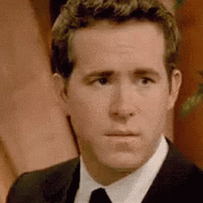 A Man In A Suit And Tie Is Looking At The Camera With A Serious Look On His Face . GIF