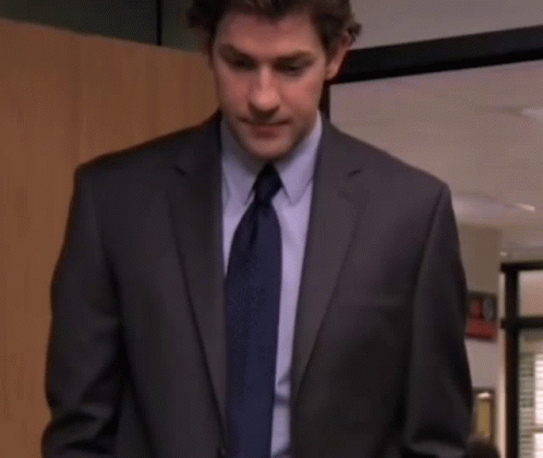 A Man In A Suit And Tie Is Looking At The Camera With A Serious Look On His Face . GIF