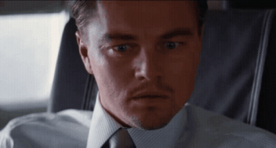 A Man In A Suit And Tie Is Looking At The Camera With A Surprised Look On His Face GIF