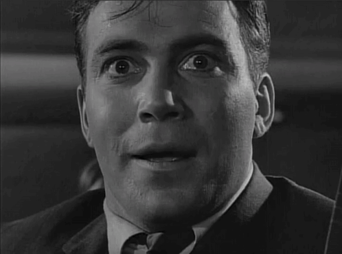 A Man In A Suit And Tie Is Looking At The Camera With His Mouth Open GIF