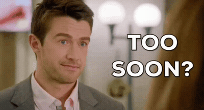 A Man In A Suit And Tie Is Looking At The Camera With The Words Too Soon Behind Him GIF
