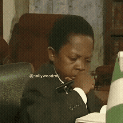 A Man In A Suit And Tie Is Looking Down At Something .. GIF