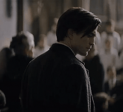 A Man In A Suit And Tie Is Looking Down GIF