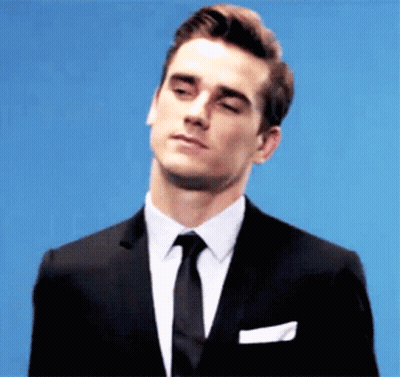 A Man In A Suit And Tie Is Looking Down GIF