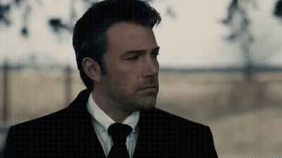A Man In A Suit And Tie Is Looking Down GIF