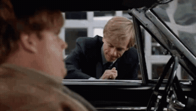 A Man In A Suit And Tie Is Looking Out The Window Of A Car . GIF