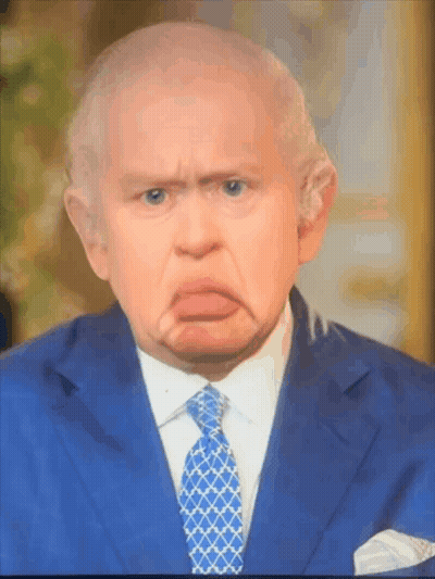 A Man In A Suit And Tie Is Making A Face GIF