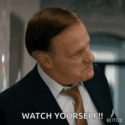 A Man In A Suit And Tie Is Making A Face And Saying `` Watch Yourself '' . GIF