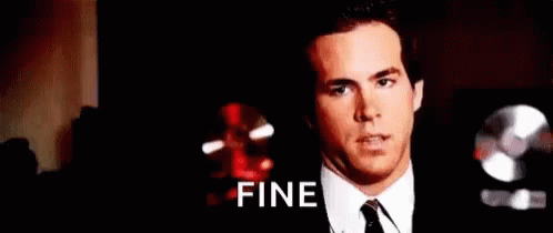 A Man In A Suit And Tie Is Making A Face And The Word Fine Is On The Screen Behind Him . GIF