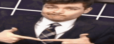 A Man In A Suit And Tie Is Making A Face GIF