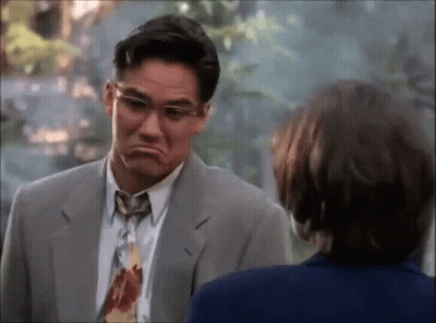 A Man In A Suit And Tie Is Making A Face GIF