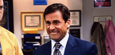 A Man In A Suit And Tie Is Making A Face In An Office . GIF