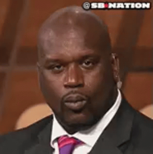 A Man In A Suit And Tie Is Making A Face . GIF