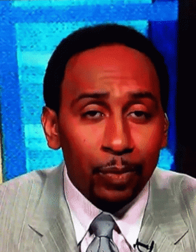 A Man In A Suit And Tie Is Making A Face GIF
