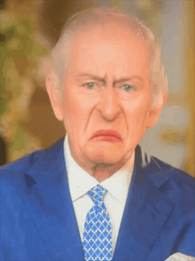 A Man In A Suit And Tie Is Making A Face GIF