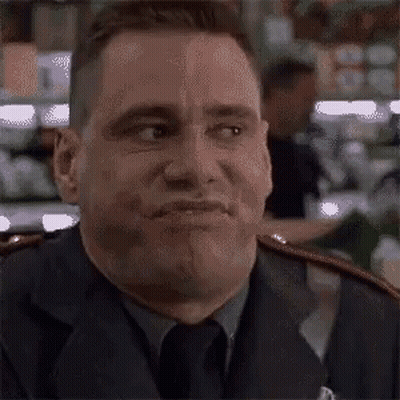 A Man In A Suit And Tie Is Making A Face . GIF