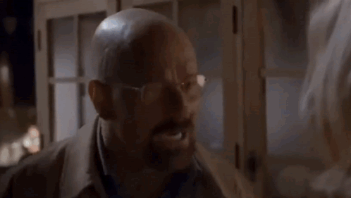 A Man In A Suit And Tie Is Making A Funny Face GIF