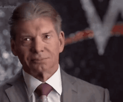 A Man In A Suit And Tie Is Making A Funny Face GIF
