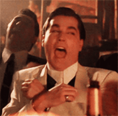 A Man In A Suit And Tie Is Making A Funny Face GIF