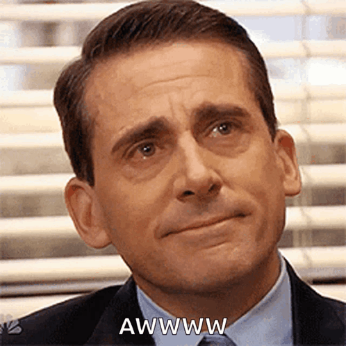 A Man In A Suit And Tie Is Making A Funny Face And Saying Awwww . GIF
