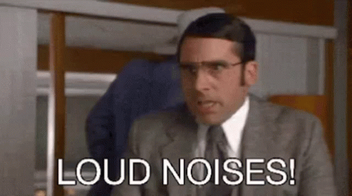 A Man In A Suit And Tie Is Making A Funny Face And Saying `` Loud Noises '' . GIF